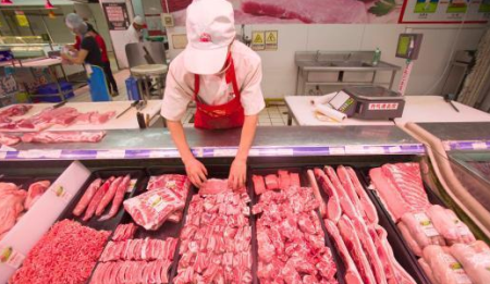 超市员工正在整理冷鲜猪肉