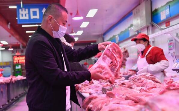 顾客在市场内挑选猪肉