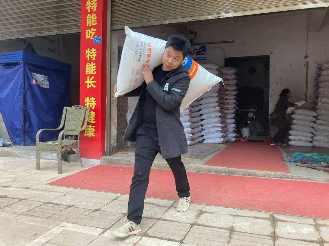 张乐营长在帮客户搬运饲料